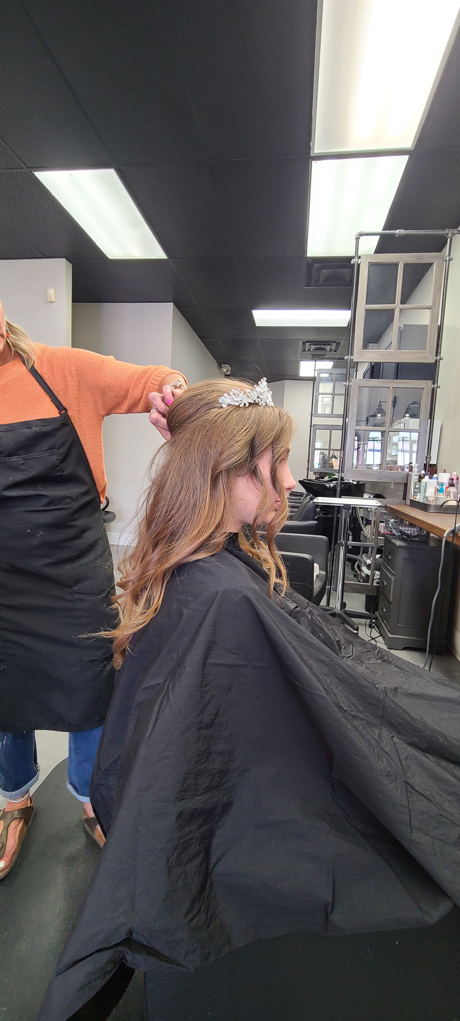 A client being styled in the salon chair